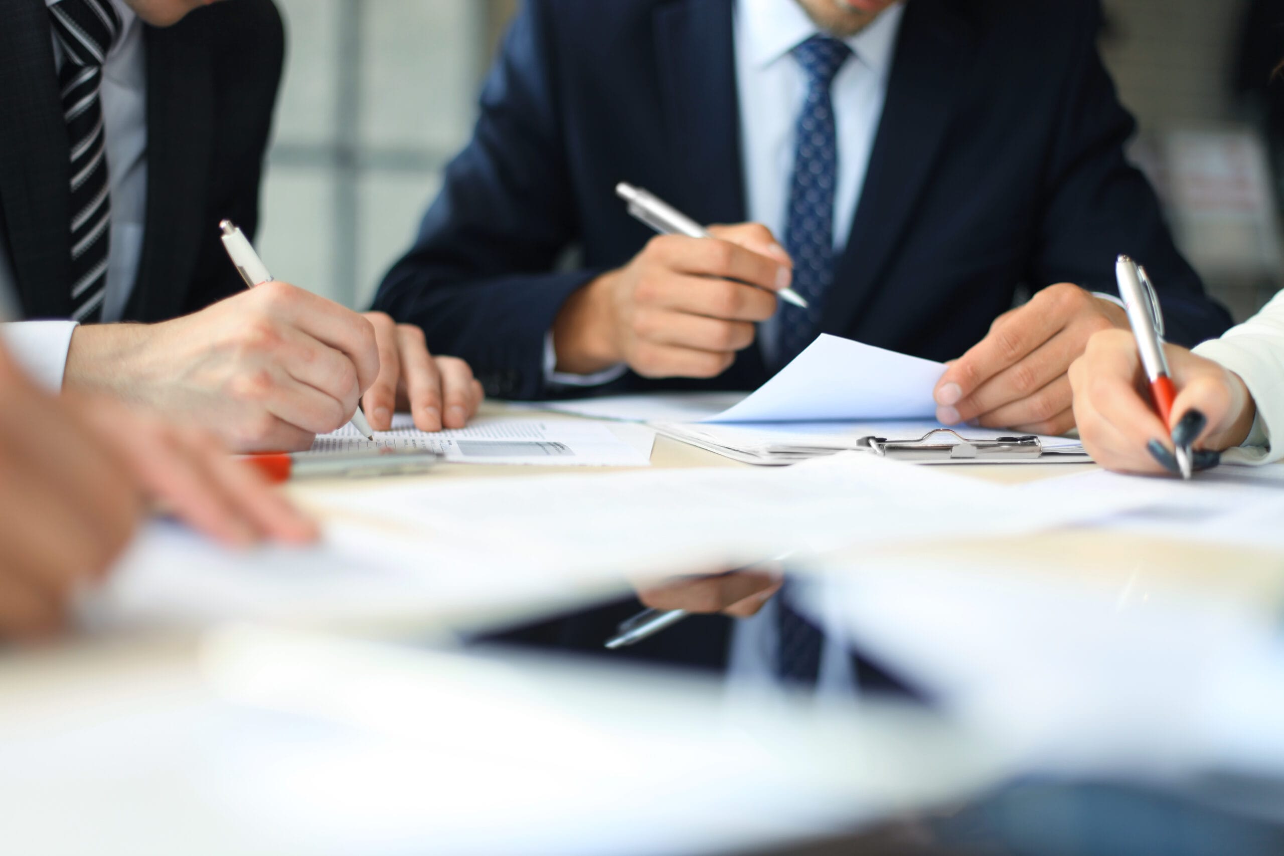 Businesswoman sitting in office, writing on documents.